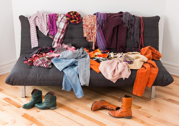 What to wear? Messy colourful clothing on a sofa.