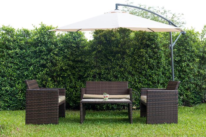 Set of rattan garden furniture under a big garden umbrella