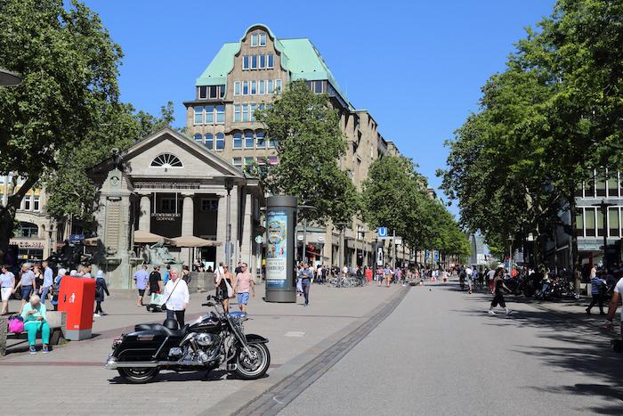 Heavy motorcycle and people walking in shopping street Monckebergstrasse in Hamburg, Germany in June