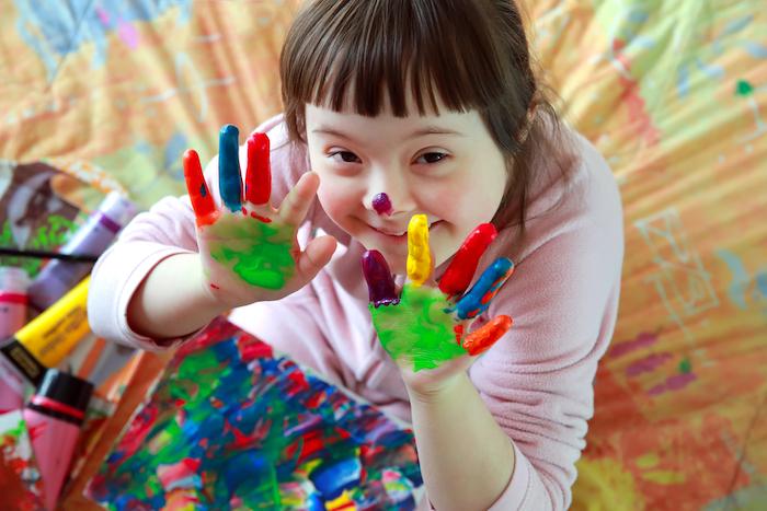 Cute little girl disabled with painted hands