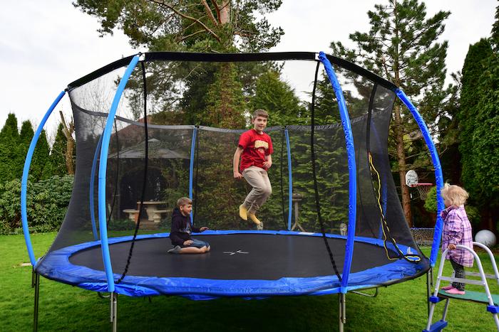 The children bought a new trampoline and put it in the yard and jump on it.