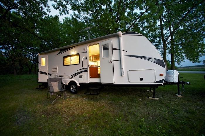 Modern 25 Feet Travel Trailer - Camping in the Forest. Evening/Dusk Photography. Recreation Photo Collection