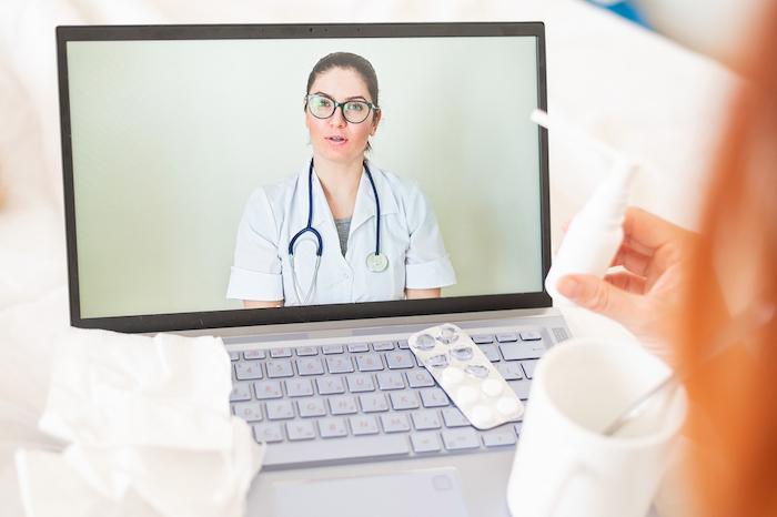 Unrecognizable girl is watching a video with medical prescriptions on a laptop. A woman conducts an online conversation with the attending physician. The doctor gives an online consultation
