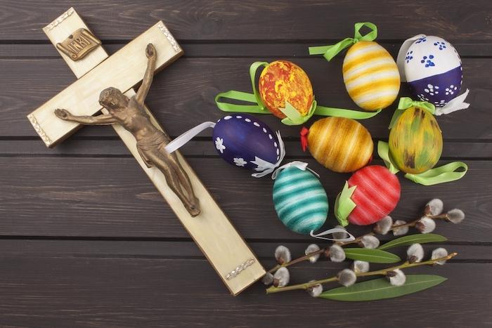 Eggs Christian Easter symbol. Preparation for Easter celebrations. Wooden cross with Christ. Resurrection, celebration of the coming of the savior. Painted eggs, spring celebration. 
