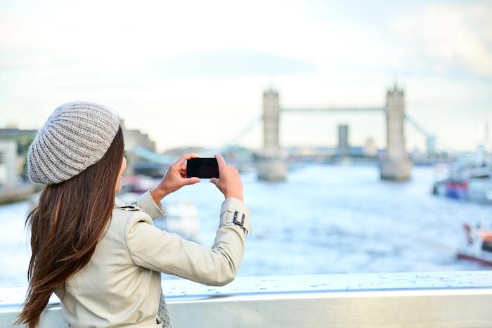 London woman tourist taking photo on Tower Bridge