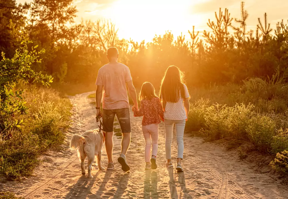 Daughters with father and dog in nature