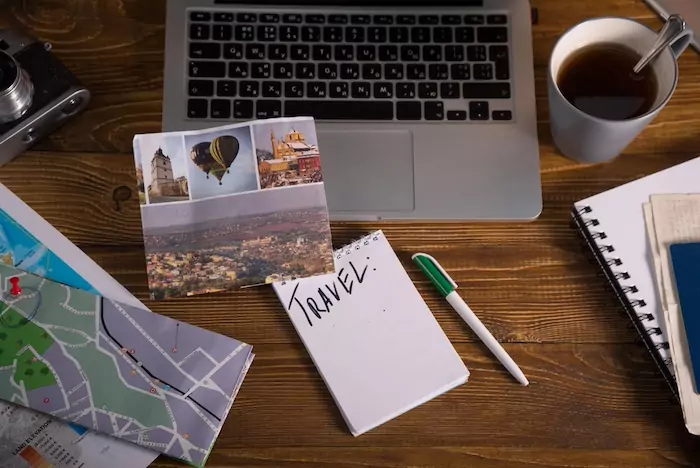 How to Plan a Balanced Travel Year with Fun and Function. Planning travel map tea laptop map on the wooden desk