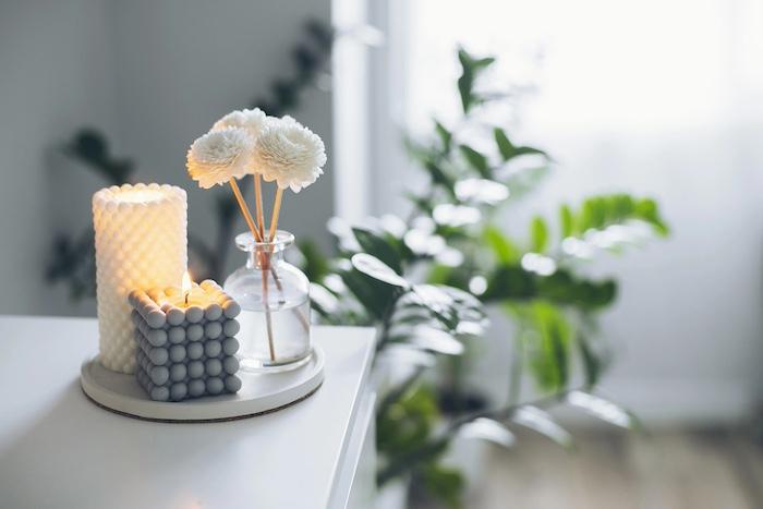 Home aroma fragrance diffuser and burning candles on table. Interior elements. Copy space