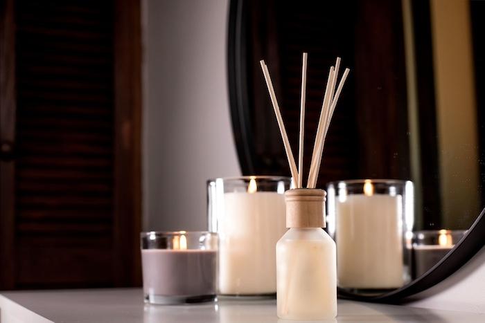Air freshener in a glass bottle and scented candles in candle holders. Home atmosphere. Fragrances for the home.
