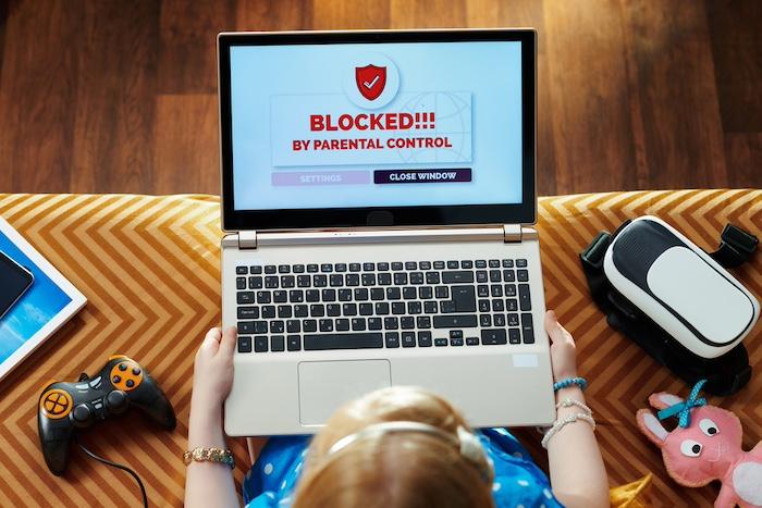 Girl having access restriction by parental control on laptop