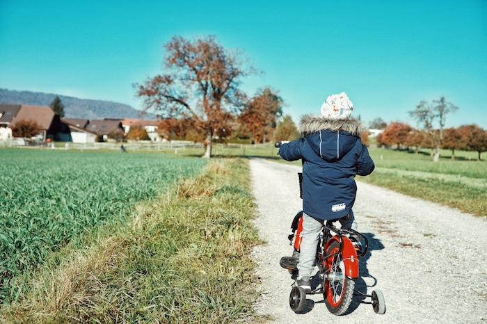Tips for biking the Camino de Santiago with family. A child riding a bike on a scenic path