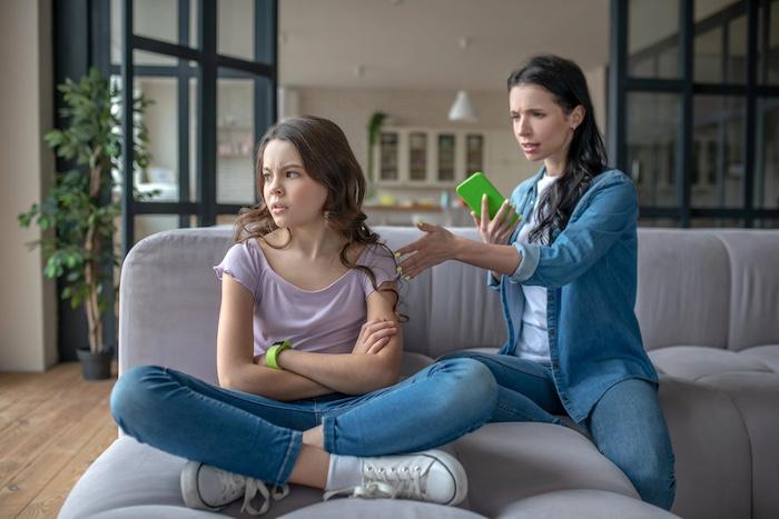 Problem. Mom in a jeans jacket talking to her daughter about internet dependence