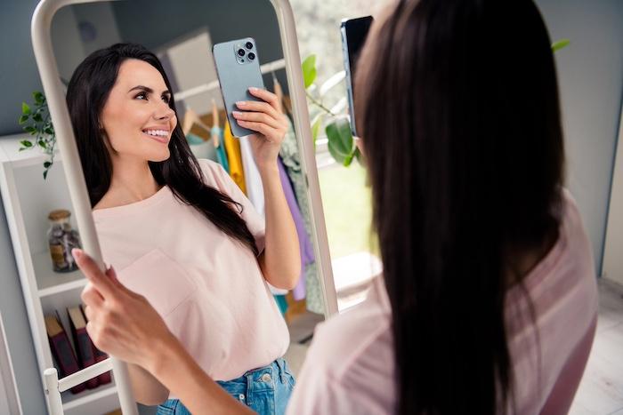 Photo of lady fashion vlogger try in new boutique store showroom fashionable shirt ask followers appearance opinion in gadget selfie.