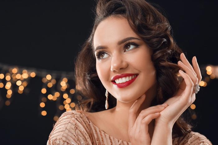 Smiling woman with stylish jewelry on dark background