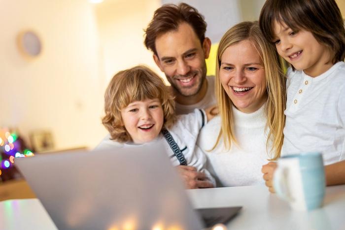 Happy young family using laptop at home