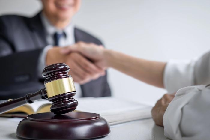 Good service cooperation of Consultation between a male lawyer and business woman customer, Handshake after good deal agreement, Law and Legal concept.