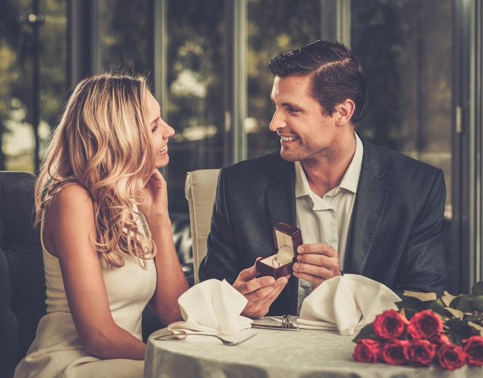 Man holding box with ring making propose to his girlfriend