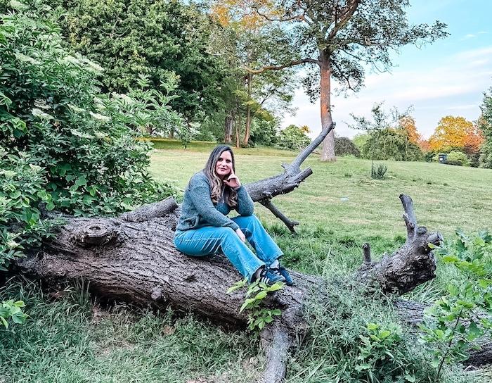 Franca wearing Cotton Traders outfit, charcoal cardigan with wide lef jeans outdoors in the park.