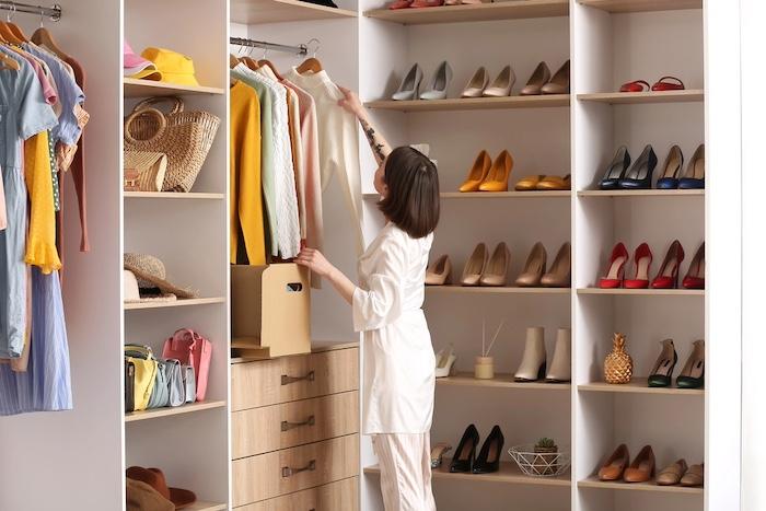 Finding Your Personal Style. Young woman arranging clothes at wardrobe