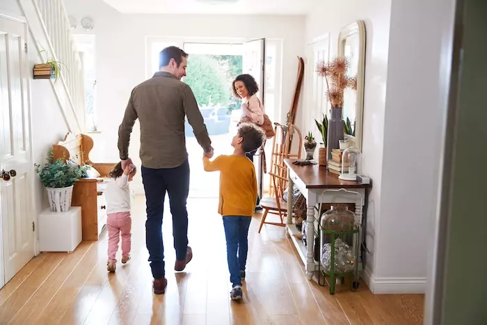 Home Maintenance Tips for a Safe and Stress-Free Home. Rear View Of Family Leaving Home On Trip Out With Excited Children