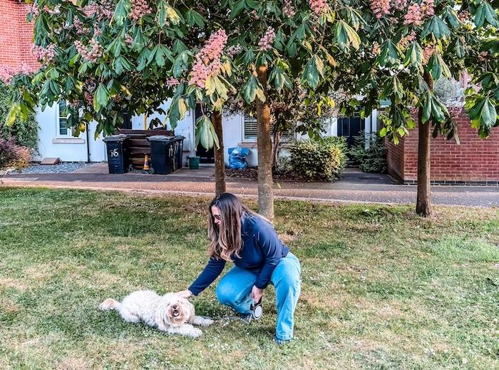 Outfit with fleece and jeans. Franca with her Maltipoo dog outside in front of a tree
