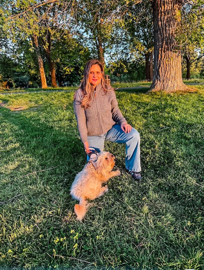 Franca wearing the Cotton Traders Sherpa Trim Cardigan with wide leg jeans outdoors at the park with her dog.