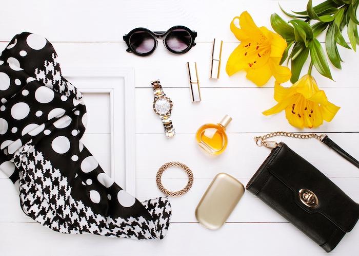 Fashion scarf, perfume, sunglasses, and flowers on white background