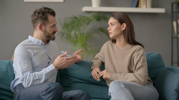 Couple having Serious Conversation while Sitting on Sofa