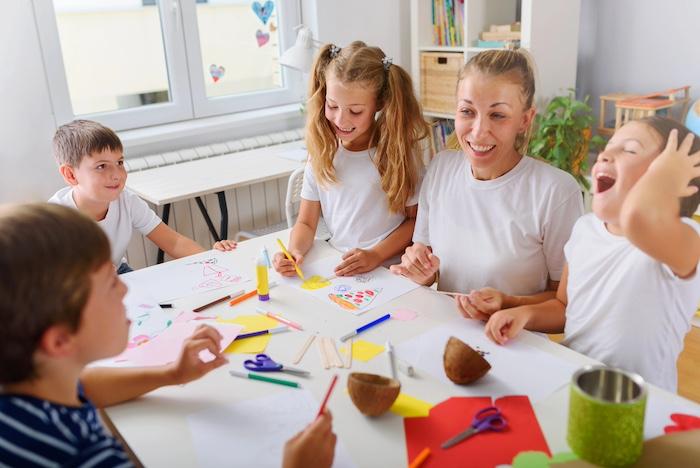 Kids making handicrafts with teacher at school