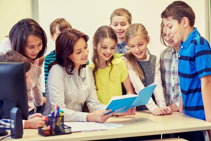 Group of school kids with teacher in classroom