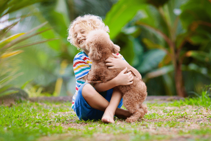 What Families Should Know Before Welcoming A Puppy Into Their Lifestyle. Children and dog in garden playing