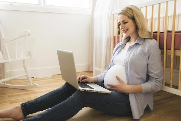 A Attractive young pregnant woman with laptop