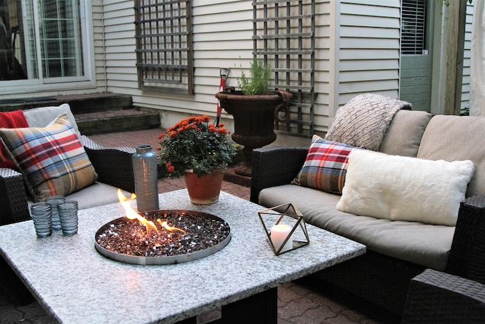 Outdoor seating arrangement around a gas fire pit table in the fall