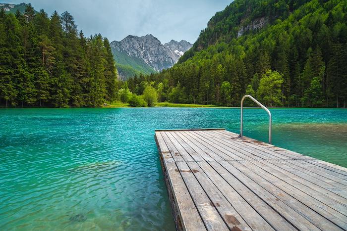 Alpine summer scenery with picturesque turquoise mountain lake. Plansarsko lake and green pine forest in Jezersko valley, Slovenia, Europe